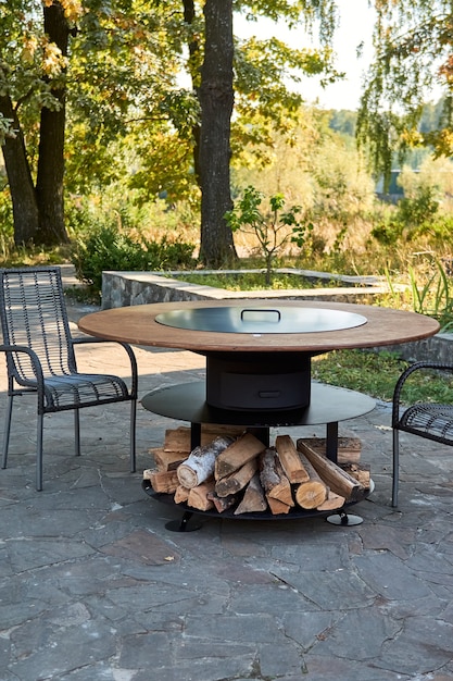 Kettle Grill Pit with Cast Iron Grid with flames . Round table-cooking surface. Hot BBQ on Backyard