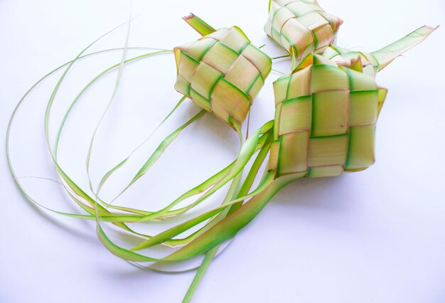 ketupat in earthenware plate isolated on white background Ketupat Rice Dumpling is food served when idhul fitri eid mubarak in Indonesia made from rice wrapped in young coconut leaves janur