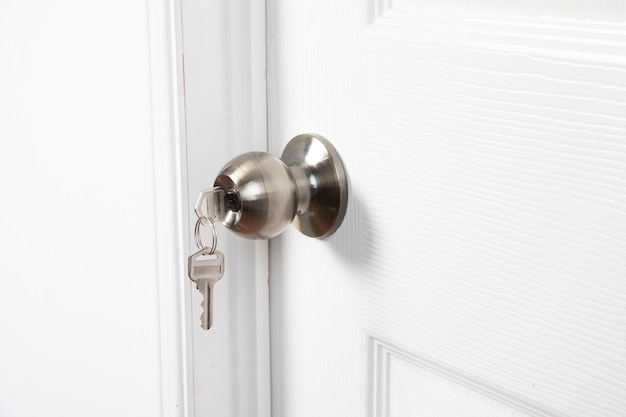 key in the keyhole on white door close up