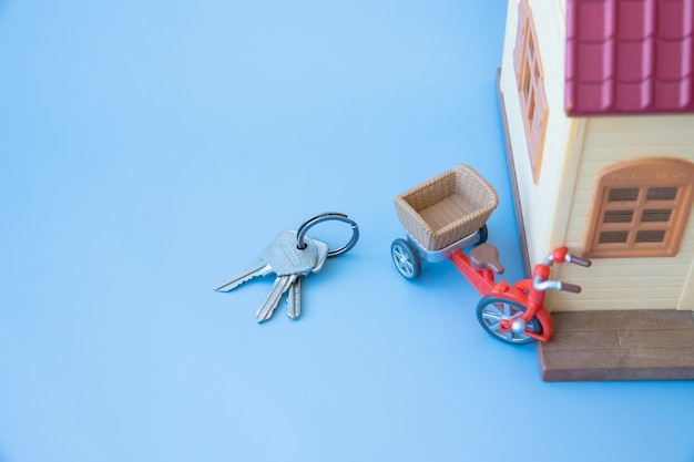 The keys are lying next to the house on a blue background rental housing