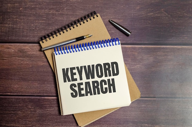 Keyword search words on notebook and wooden background