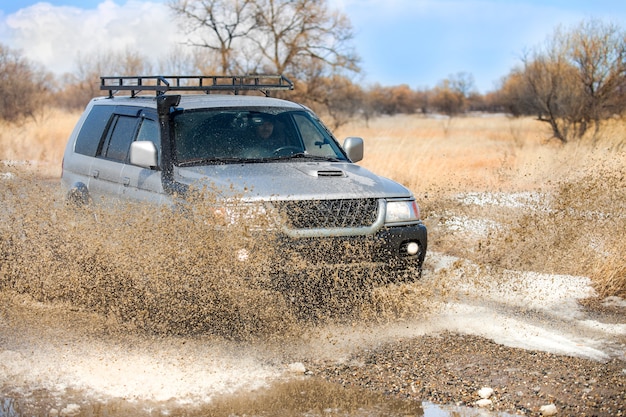 KHABAROVSK, RUSSIA - MARCH 25, 2017: Mitsubishi Pajero Sport on dirt road in early spring making splashes from a puddle