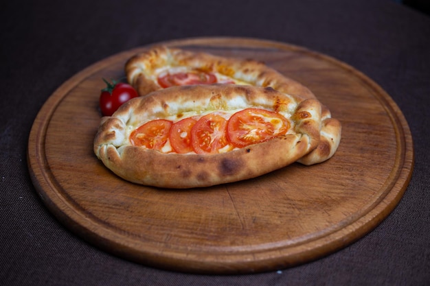 khachapuri recipe with tomatoes khachapuri on a wooden plate