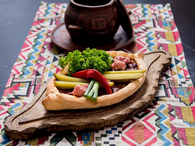 Khachapuri with cheese, vegetables and eggs. Georgian national cuisine.