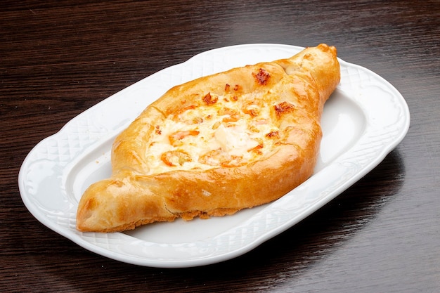 Khachapuri with shrimp and cheese On a wooden background