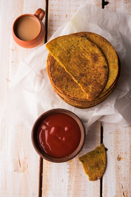 Khakhra or Khakra is a thin cracker is a popular Jain, Gujarati and Rajasthani  breakfast food. Served with Hot Tea and Tomato Ketchup. Over colourful or wooden background