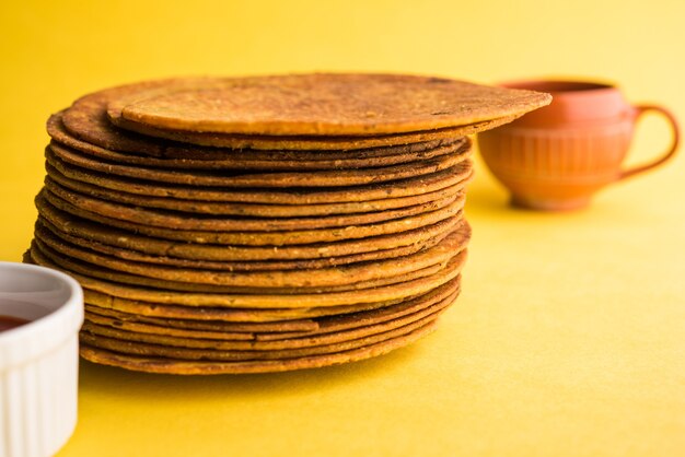 Khakhra or Khakra is a thin cracker is a popular Jain, Gujarati and Rajasthani  breakfast food. Served with Hot Tea and Tomato Ketchup. Over colourful or wooden background