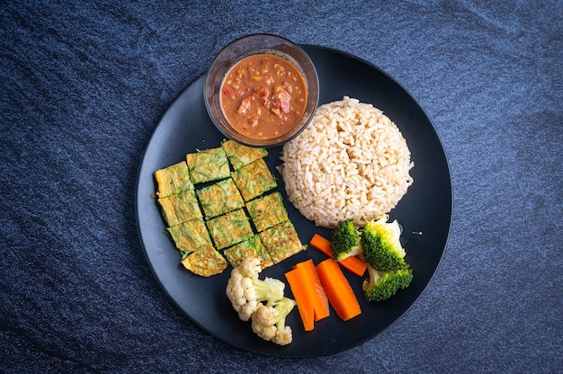 Khao khluk kapi (Thai traditional shrimp rice) in dish on dark, local food of Thailand