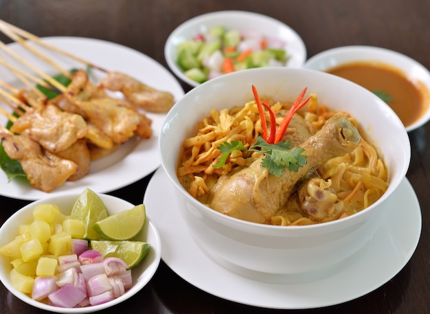 Khao Soi Chicken, northern Thai noodle dish with chicken and coconut curry soup, shown with crispy noodles and other vegetables