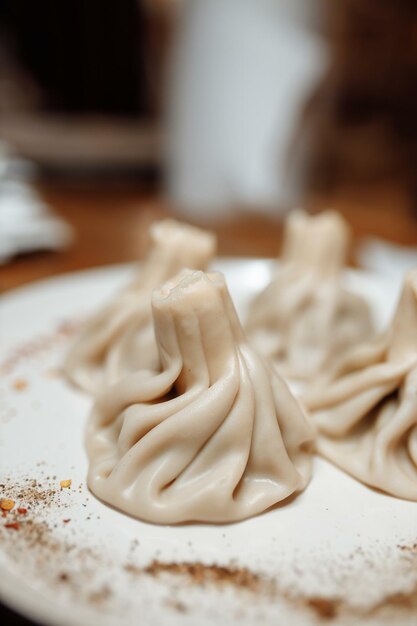 Khinkali cooked on a ceramic white plate.