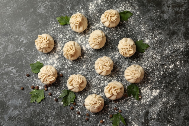 Khinkali, spices and flour on black smokey