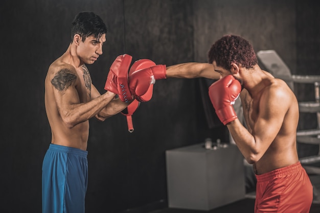 Kickboxing. Young men training in a gym and looking involved