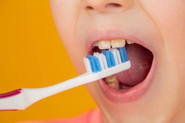 Kid boy brushing teeth Boy toothbrush white toothpaste Health care dental hygiene Joyful child shows toothbrushes Little boy cleaning teeth Dental hygiene Happy little kid brushing her teeth