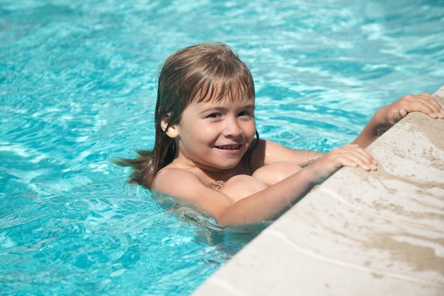 Kid boy swim in swimming pool kids summer vacation concept