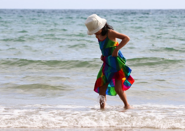 Kid catching her skirt from water on the beach happiness and relax time in summer