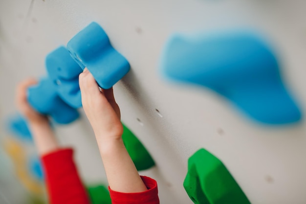 Kid child hands close up at climbing wall Children sport healthy lifestyle in kindergarten or sport center in school