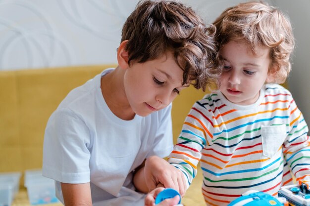 Kid collects robot from plastics details and programmed on tablet robotics