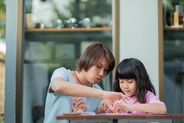 Kid doing homework with mother, family concept, learning time, student, back to school