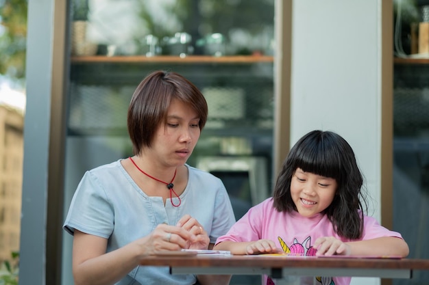 Kid doing homework with mother family concept learning time student back to school