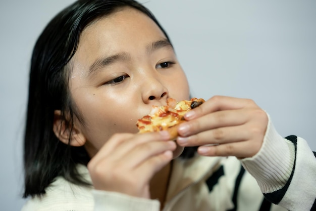 Kid eating pizza on white background