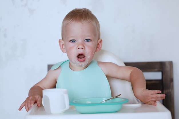 kid eats with a spoon and learns by himself