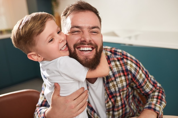 Kid embracing happy father at home