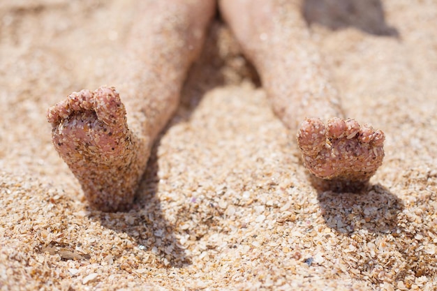 Kid feet on the sand rest and childhood sea air