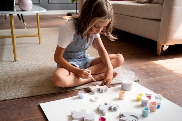 Kid on floor painting full shot