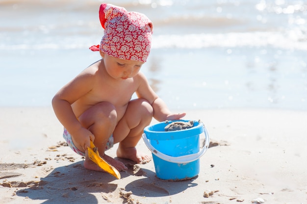 Kid girl play on a beach. 