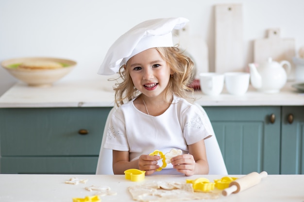 Kid girl preparing food at kitchen at home