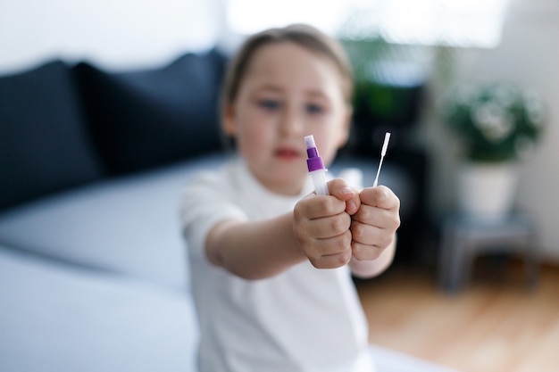 Kid girl with test strip for antibody or sars-cov-2 virus disease in hands