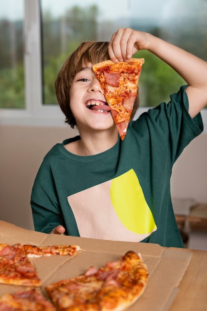 Kid having fun while eating pizza