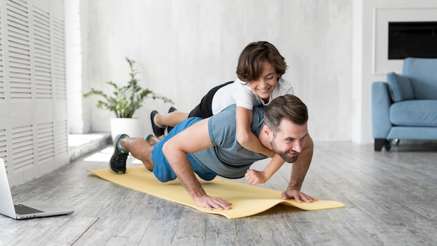 Kid and his father doing sport at home