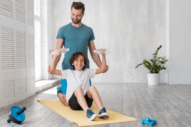 Kid and his father doing sport at home