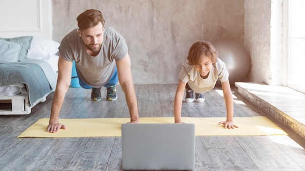 Kid and his father doing sport at home