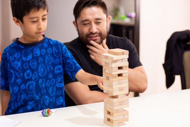 Kid and his father playing block game togethjer