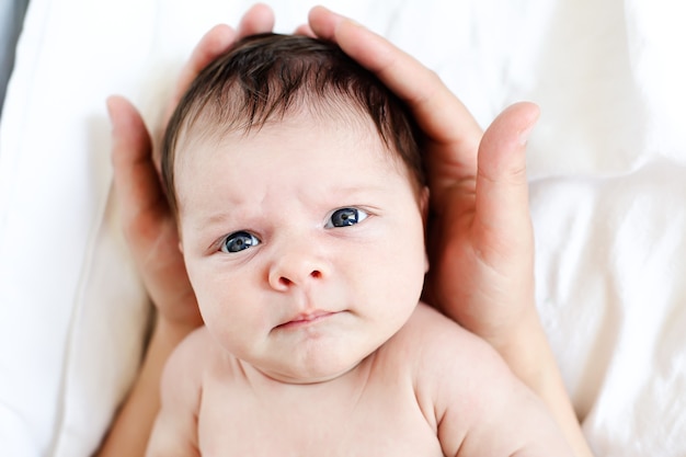 The kid in his mother's gentle hands