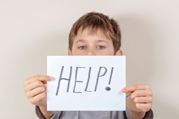 Kid holding paper sheet with word help