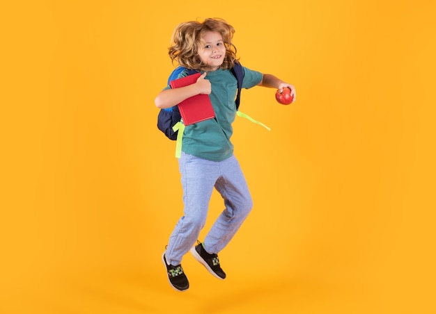 Kid jump and enjoy school Photo of excited little school jumping holding book empty space isolated