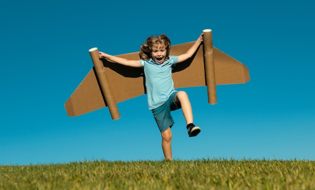 Kid pilot with toy jetpack against sky background happy child playing outdoors happy childhood child