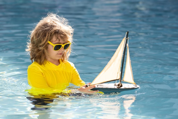 Kid playing on the beach child play on the sea with toy ship boat little child having a happy moment