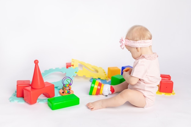 The kid plays with cubes on a white isolated background, space for text