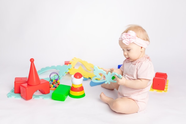 The kid plays with cubes on a white isolated background, space for text