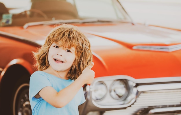 Kid refuel the car gas station happy boy against red retro automobile