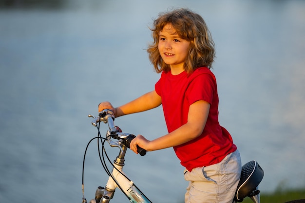 Kid riding bike happy kid boy riding bike in summer park