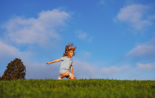 Kid running on grass field Cute boy run in summer park Child running on meadow