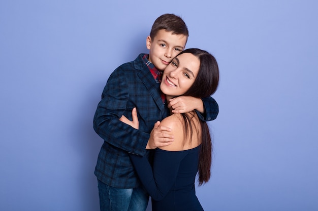 Kid on a suit hugging his mother