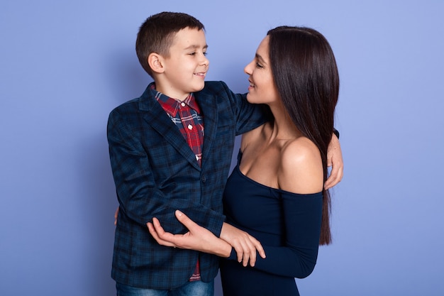 Kid on a suit hugging his mother