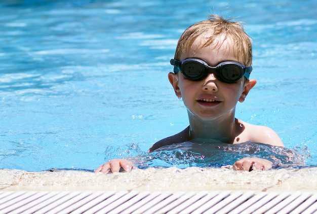 Kid swimming in the pool with goggles