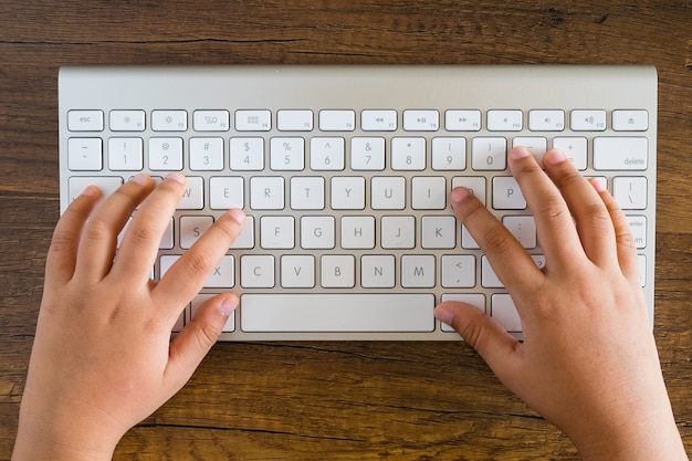 Photo kid typing a keyboard for surfing